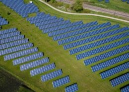 Aerial view of many solar panels in a green field. Photo.